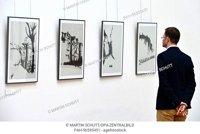 A visitor examines drawings by artist Klaus Bose at the exhibition venue 'Kunsthalle Harry Graf Kessler' in Weimar, Germany, 11 March 2015