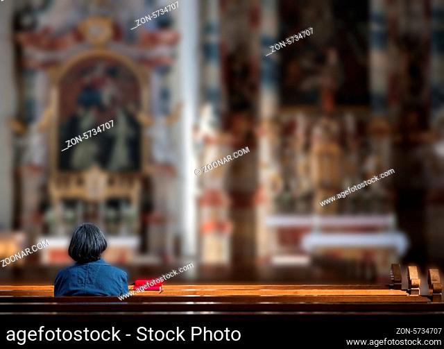 Seniorin in aller Stille und Ruhe innerhalb einer Kirche