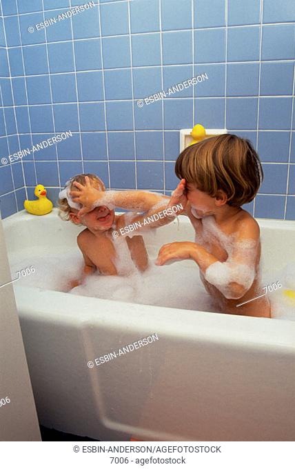 Two rambunctious brothers in bubble bath