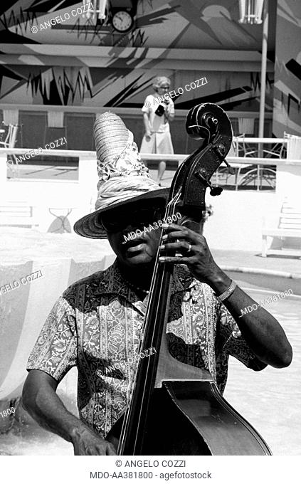 Contrabass player. A musician playing the contrabass. Bermuda, 1965