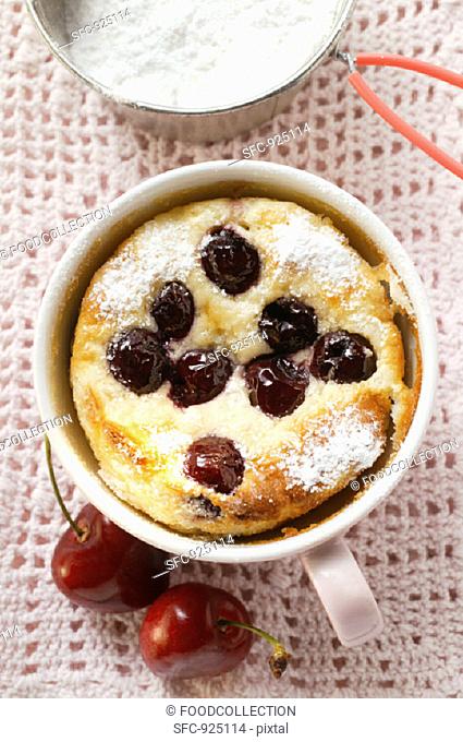 Quark and semolina pudding with cherries and icing sugar in cup