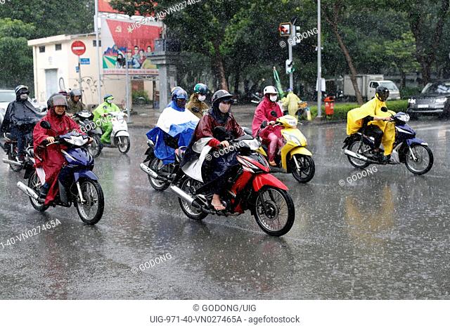 Heavy monsoon rain. Vietnamese people driving Motorbikes on Saigon Street. Ho Chi Minh City. Vietnam