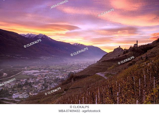 Sunset with lenticular clouds from wineyards that overlook Sondrio and Grumello Castle with Church of San Antonio. Montagna in Valtellina, Valtellina, Lombardy