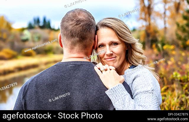 A married couple spending quality time together outdoors in a city park during a warm fall afternoon; St. Albert, Alberta, Canada