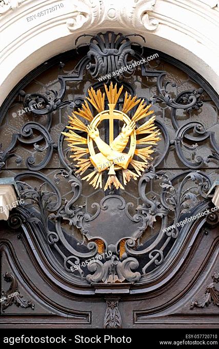 Franciscan monogram on the main entrance, Mariahilf church in Graz, Styria, Austria