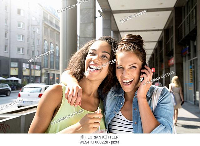 Germany, Berlin, Young women in the city, using mobile phone