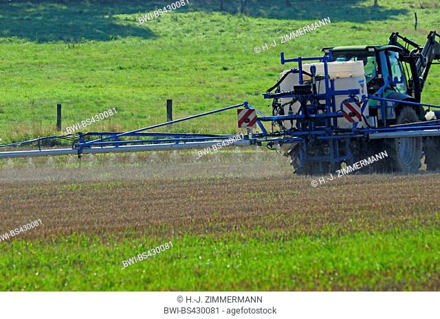 tractor spraying glyphosat on a field in summer, Germany, Rhineland-Palatinate, Westerwald