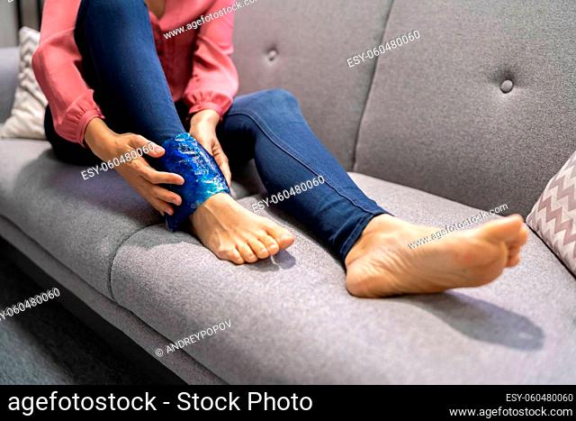 Woman Holding Icing Gel Therapy Pack After Leg Injury