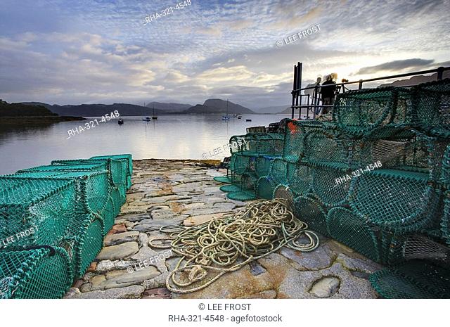 View out to sea from stone slipway at dawn, with lobster pots and ropes in foreground, Plokton, near Kyle of Lochalsh, Highland, Scotland, United Kingdom