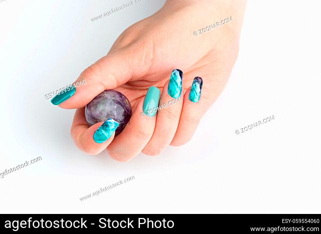 Closeup of woman nails with creative purple and green manicure. Fluorinit print. Copy space