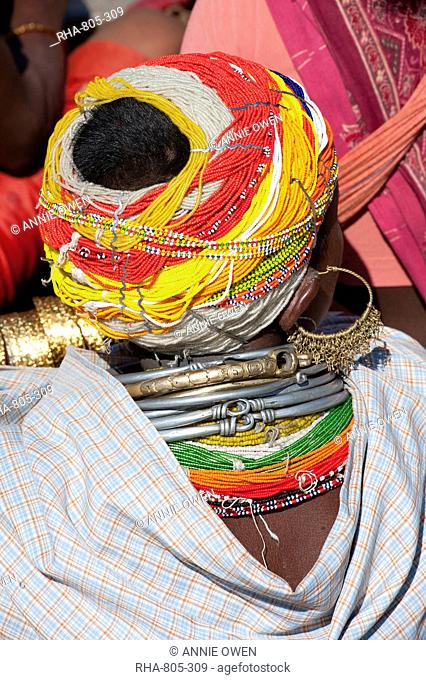 Head of Bonda tribeswoman wearing traditional beaded cap held with metal clips, large earrings and metal and bead necklaces, Rayagader, Orissa, India, Asia