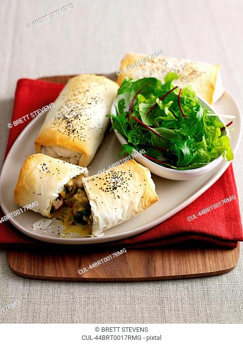Plate of baked pastry rolls with salad