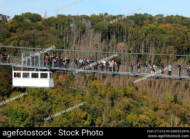 10 October 2021, Saxony-Anhalt, Wernigerode: Visitors enjoy the autumn weather on the suspension bridge at the Rappbode dam