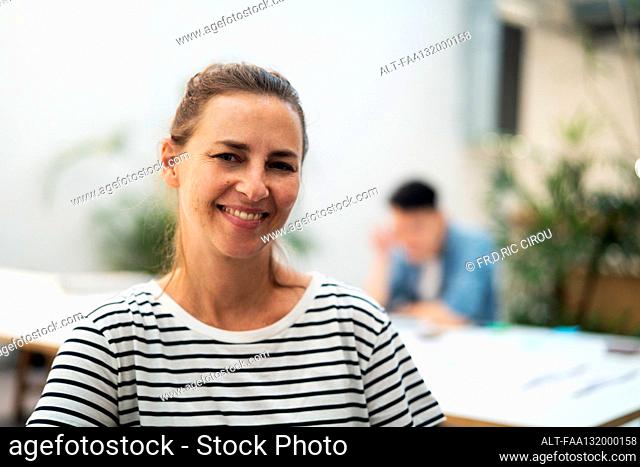 Female architect looking and smiling at the camera while standing in office