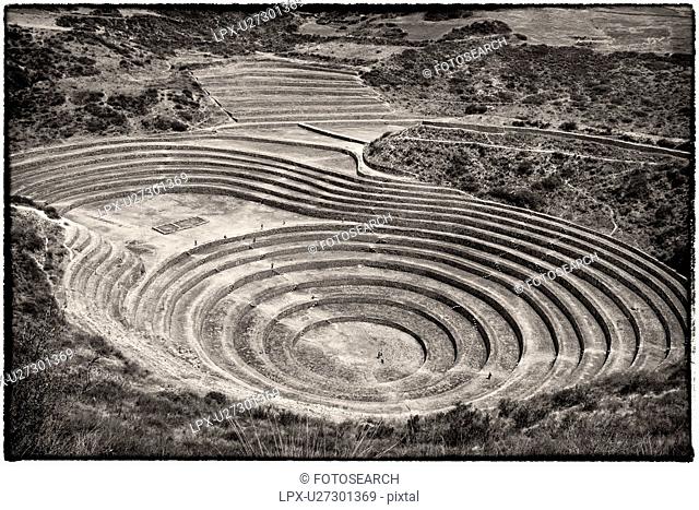Monochrome aerial view of Moray Inca agricultural terraces in large circular patterns, Maras, Sacred Valley, Peru