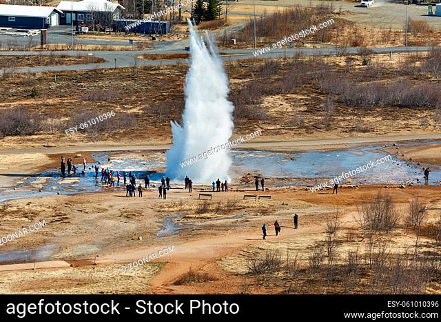 Erupting geyser in Iceland, Strokkur, spectators standing nearby