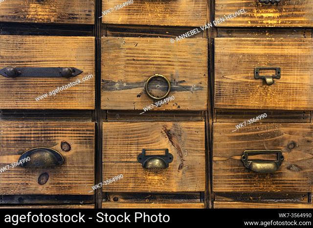 Old antique wooden drawers, rows of little drawers in an old furniture module, Storage archive wooden background texture vintage look close-up