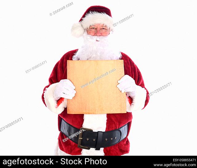 Santa Claus holding a piece old yellowed parchment paper in fornt of his torso, isolated on white. Blank paper with copy space