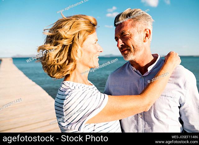 Happy mature couple looking at each other on sunny day
