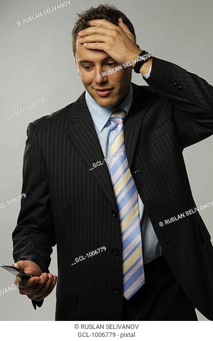 Businessman looking at his mobile phone in disbelief
