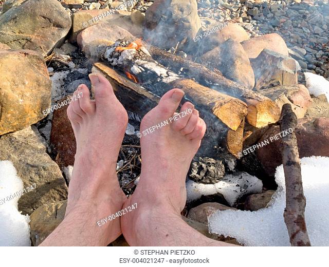 Bare Feet warming at a Campfire in winter