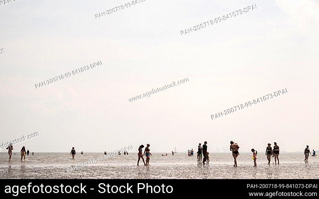 18 July 2020, Lower Saxony, Schillig: Beach visitors are at summery temperatures on the North Sea beach of Schillig. Photo: Mohssen Assanimoghaddam/dpa
