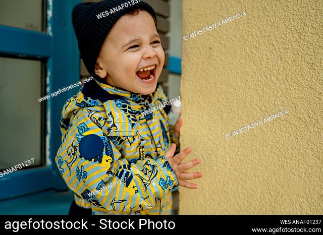 Happy boy screaming near wall