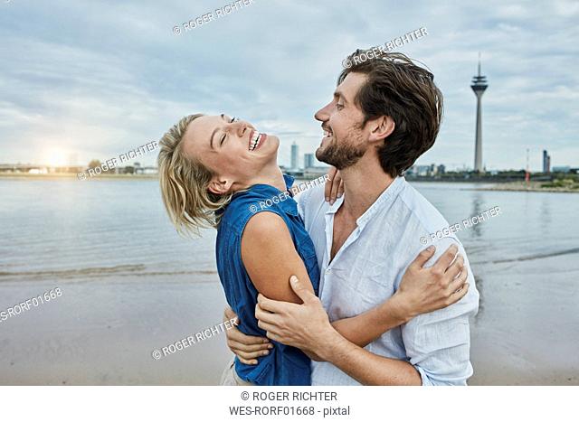 Germany, Duesseldorf, happy young couple at Rhine riverbank