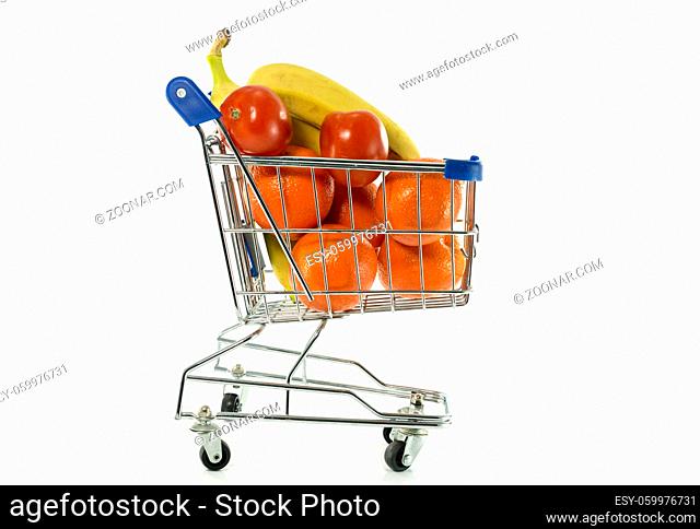 shopping cart with fresh fruit as bananas oranges and red tomato