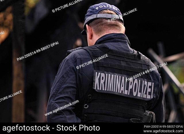 13 May 2020, Saxony, Dresden: Police officer with the inscription Kriminalpolizei on his back is in the middle of the picture