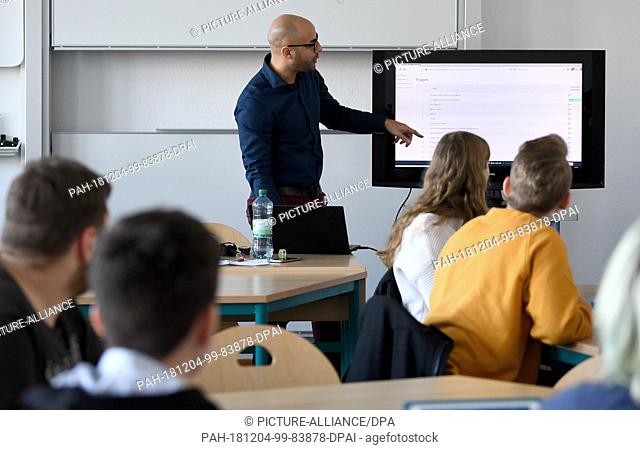 28 November 2018, Berlin, Neustrelitz: Jasin Pe-a Cabrera, English teacher at the Carolinum grammar school in Neustrelitz, teaches with the help of an iPad
