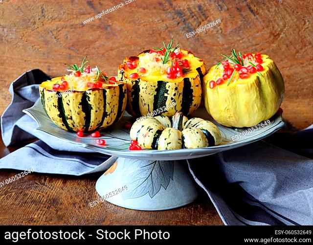 Pumpkin risotto served in a hollowed pumpkin. Baked pumpkin with cheese and pomegranate seeds . Selective focus