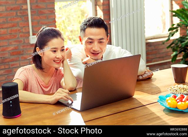The young couple watch computer at home
