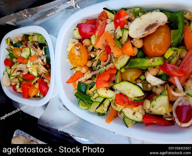 Grilled vegetables on a barbecue grill in a white bowl, top view