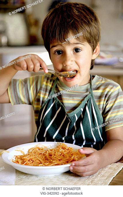 Boy eats spaghetti in the kitchen. - MAJORCA, SPAIN, 14/12/2006