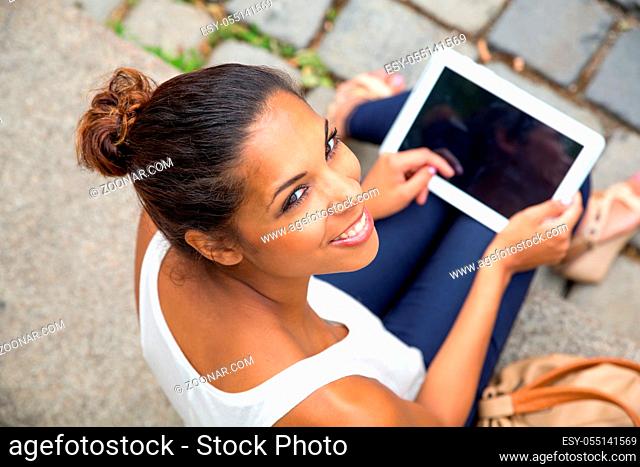 Hispanic girl using tablet in the city