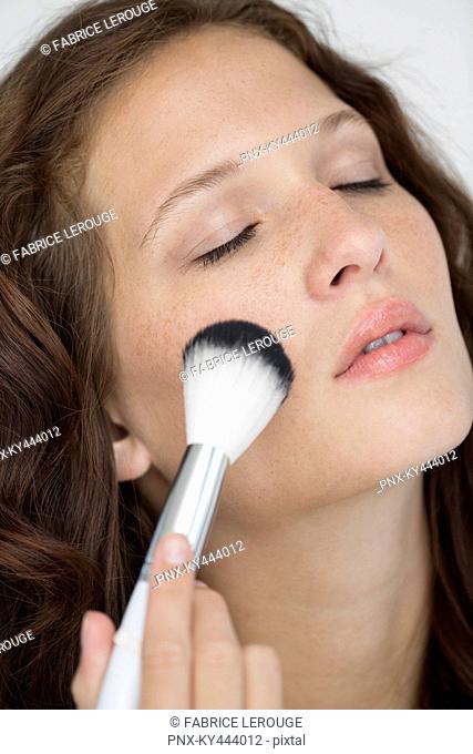 Woman doing make-up with a make-up brush