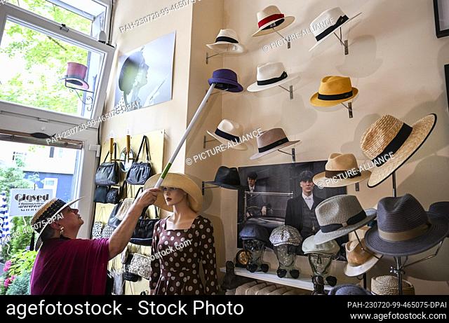 19 July 2023, Berlin: In her studio in the Günzelkiez in Wilmersdorf, milliner Petra Benz arranges Panama and summer hats