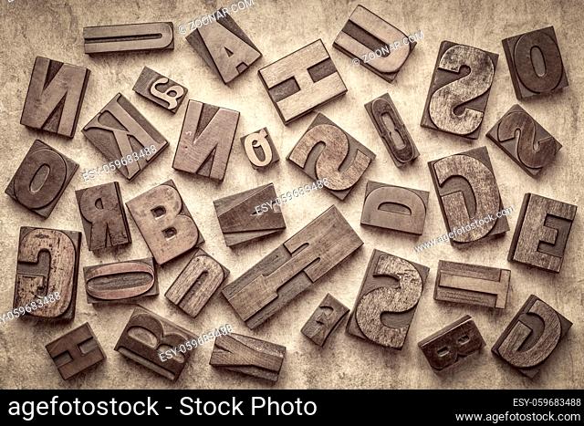 random letters overhead background - vintage letterpress wood type of different fonts (inverted image) against handmade bark paper