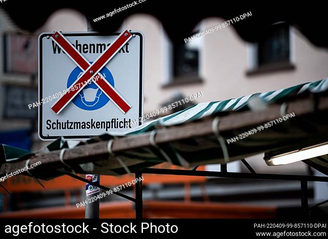 09 April 2022, North Rhine-Westphalia, Oberhausen: On a sign, which is crossed out, it says ""Weekly market - protective mask obligation""