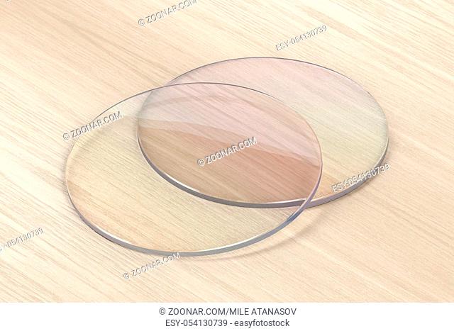 Pair of eyeglasses lens on wood background