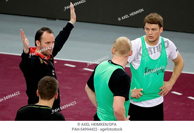 Germany's head coach Dagur Sigurdsson (L) talks to Germany's Erik Schmidt (l-r), Patrick Wiencek and Paul Drux during the training of Team Germany prior to the...