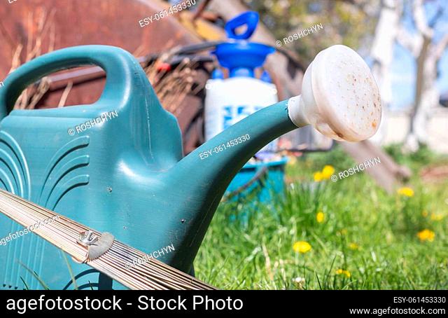 Blue plastic pot for watering in the garden. Can water. Watering can for flowers on the street, in the garden or garden on a warm summer sunny day