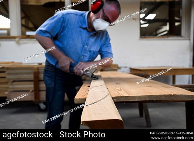 05 May 2022, North Rhine-Westphalia, Cologne: Erich Allescher, head of Peter Braun Sargfabrik, works on a coffin decoration