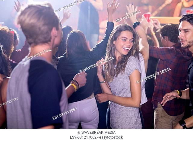 Happy people dancing at nightclub