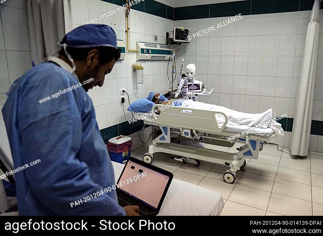 03 December 2020, Egypt, Tanta: A picture made available on 04 December 2020 shows mechatronics engineer Mahmoud El Koumy monitoring his Cira-03 robot while it...