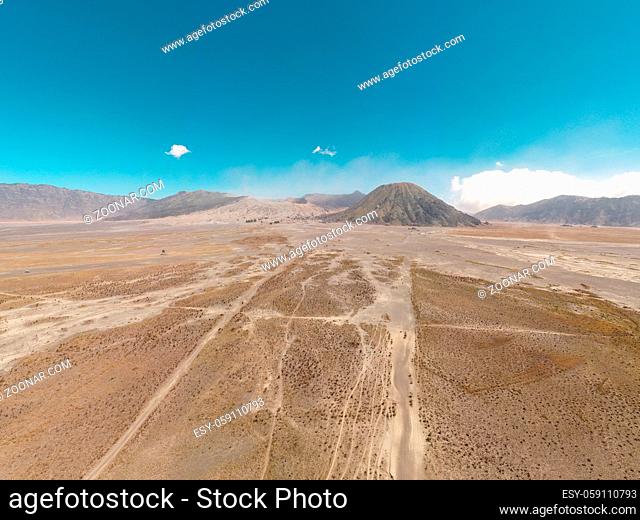 Cinematic shot aerial drone view of beautiful Mount Bromo volcano with desert in East Java, Indonesia