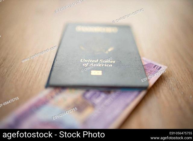 United States of America Passport with a Blurry Two Honduran Lempiras Bill under it, and both on a wooden table
