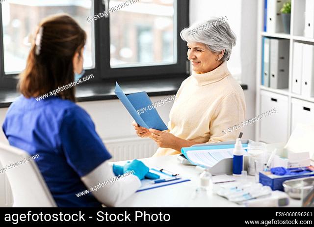 doctor and senior woman reading medical brochure