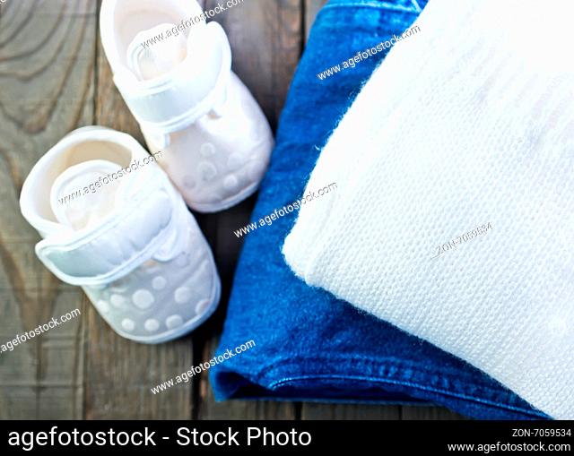 baby clothes on the wooden table, shoes for baby